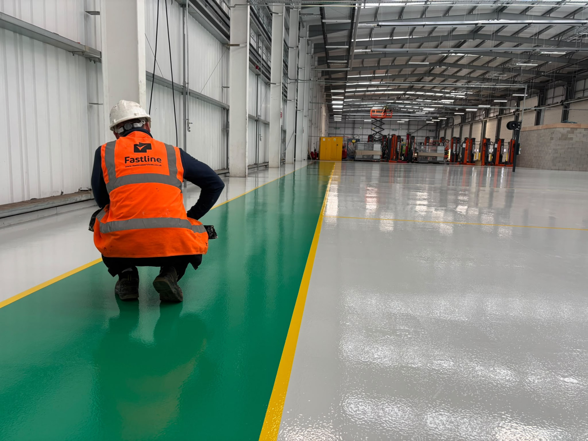 Fastline operative inspecting a fresh green walkway with yellow edge line